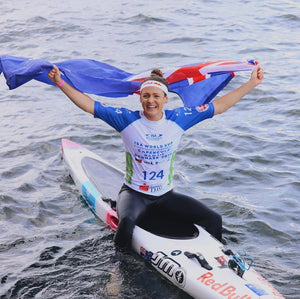 Jordan Mercer, Surf Ironwoman SUP Champion Red Bull Athlete with Australian flag after winning the ISA World Sup Competition with the Australian team
