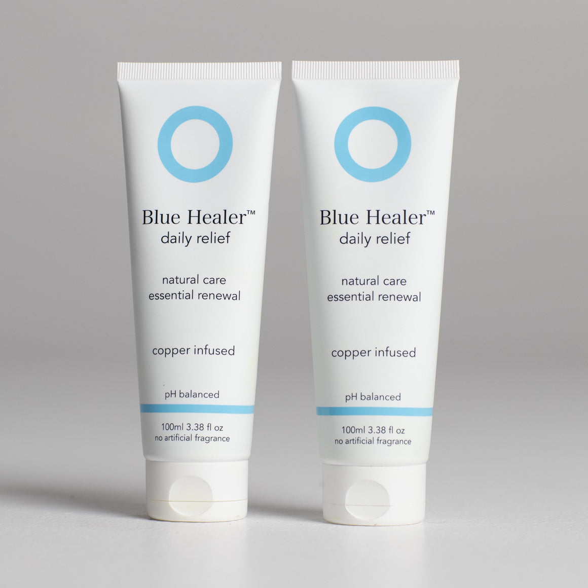 Image is of two tubes of Blue Healer Daily Relief Cream next to each other. The label reads "Blue Healer Daily Relief, natural care, essential renewal and copper infused. pH balanced with no artificial fragrance. 100ml, 3.38 fluid ounces".
